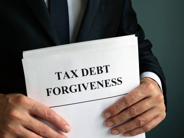 istock Man holds Tax debt forgiveness agreement. 1185407316