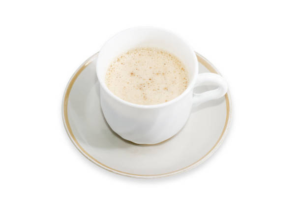 Coffee prepared with foamed cream in the white cup on saucer on a white background