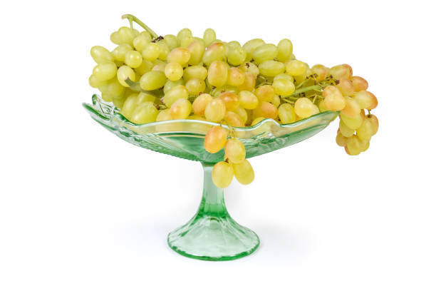 istock Sultana grape clusters on vintage fruit vase on white background 1185407382