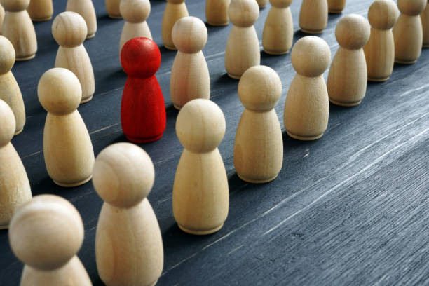 istock Unique and different concept. Crowd of wooden figures and red one. 1185407405