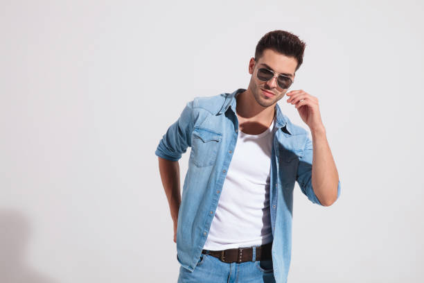 istock Charming casual man about to take off his sunglasses 1185407421