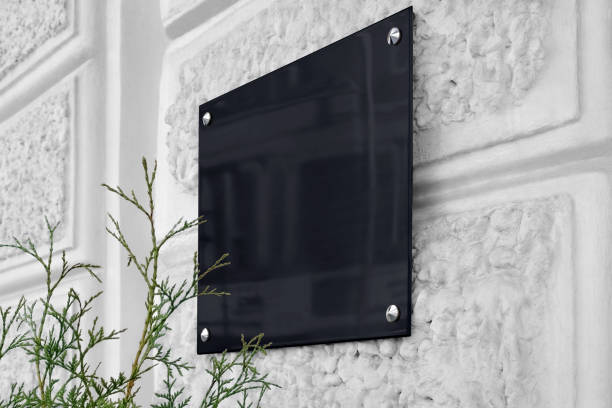 istock Blank black glass signboard on gray textured wall mockup 1185408431