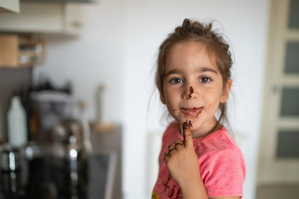 istock Child eating chocolate with her finger 1185410275