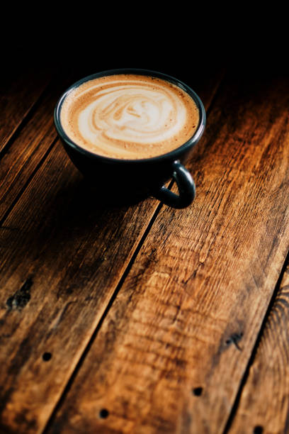 Creamy Mocha coffee on a dark rustic wooden tabletop.