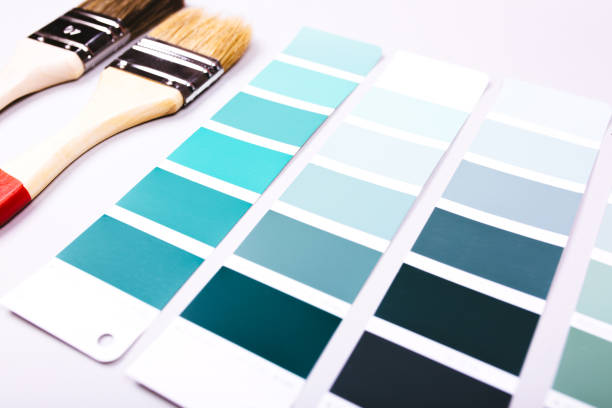 istock Two paint brush laying on heap of color samples. 1185413286