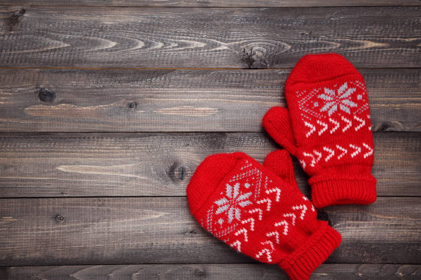 istock Knitted mittens on wooden table 1185417106