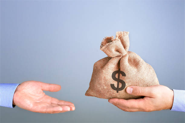 el hombre sostiene, da una bolsa de dinero en la mano como un bono. hombre de negocios sosteniendo bolsa de dinero en la mano ofreciendo soborno con espacio de copia. - returning fotografías e imágenes de stock