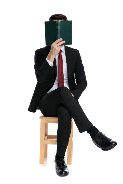 istock Mysterious businessman covering his face with a book 1185417957