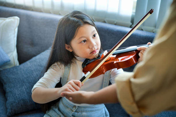 istock Asian kid learning and practicing to play violin at home 1185419497