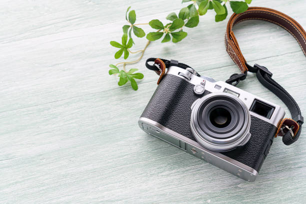 istock Old style digital cameras isolated on wooden background 1185419724