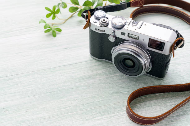 istock Old style digital cameras isolated on wooden background 1185419767
