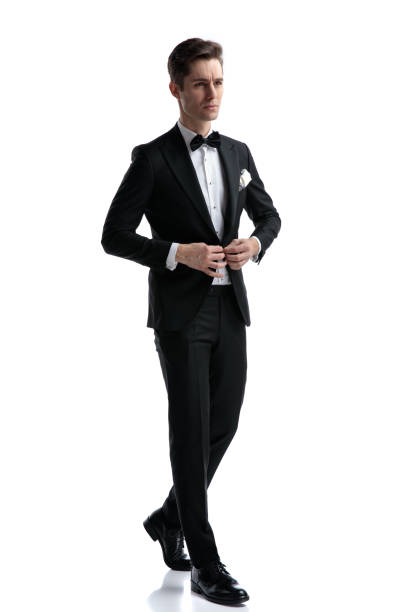 istock confident young man walking and arranging coat 1185419929