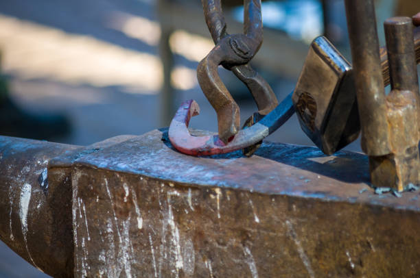 istock blacksmith performs the forging of hot glowing horseshoe on the anvil 1185420945