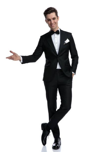 istock smiling elegant man in tuxedo inviting and presenting to side 1185421047