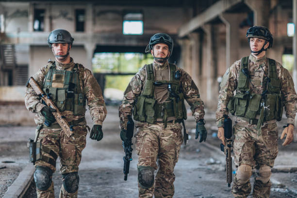 istock Three soldiers walking in abandoned warehouse 1185421179