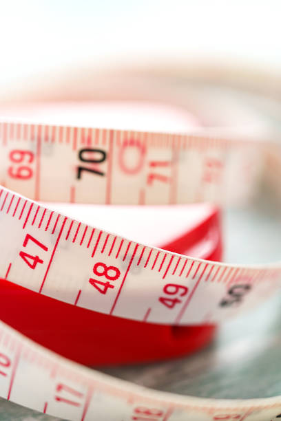 White measuring tape isolated on wooden background