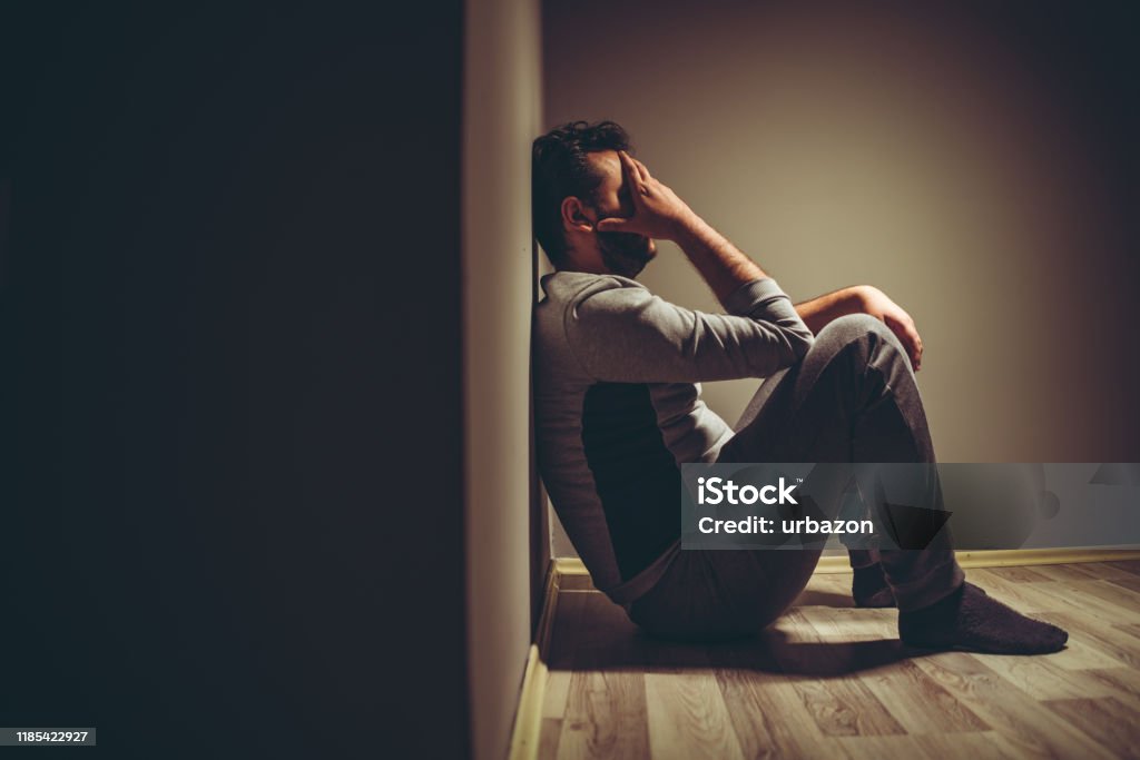 Depressive man Young depressed man sitting on floor. Men Stock Photo