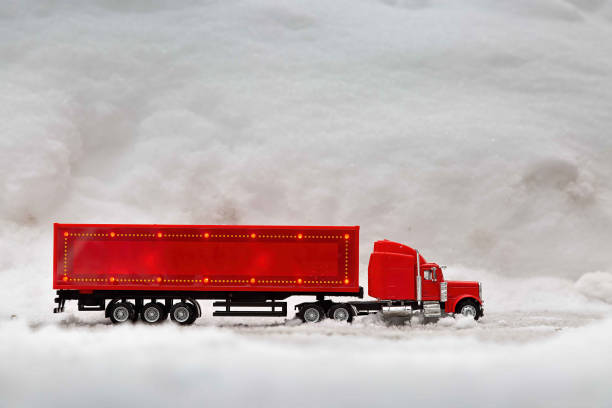 Festive truck in red. toy car rides on the background of real snowdrifts. Winter. Christmas holidays. stock photo