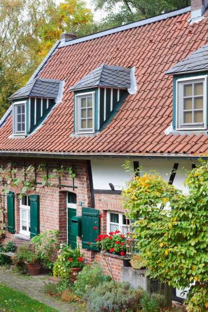 Half timbered house in Paderborn Half timbered house in Paderborn with plants in front yard. Windows have shutters. On roof are dormers. Seen near park with Pader springs. paderborn stock pictures, royalty-free photos & images