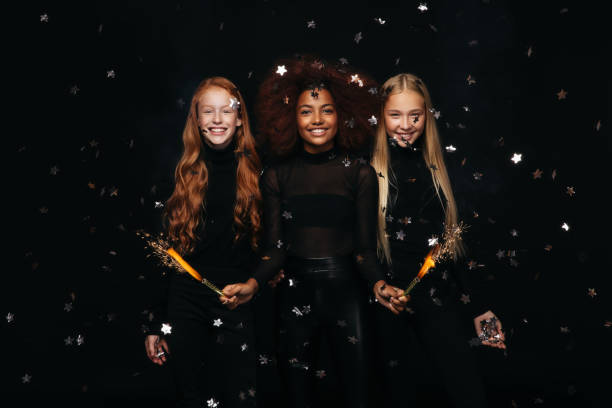 Three happy young girls celebrates New Year Three happy young girls celebrates New Year girl band stock pictures, royalty-free photos & images