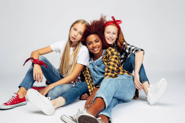 trois belles jeunes filles s'asseyant au studio - sitting isolated child beautiful photos et images de collection