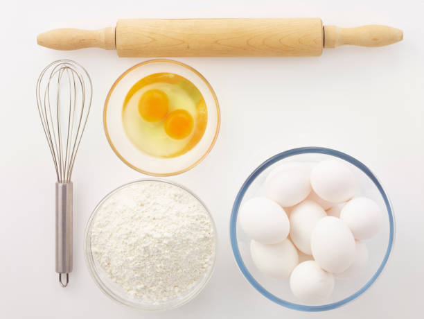 eggs, whisk, flour and rolling pin in the white background
