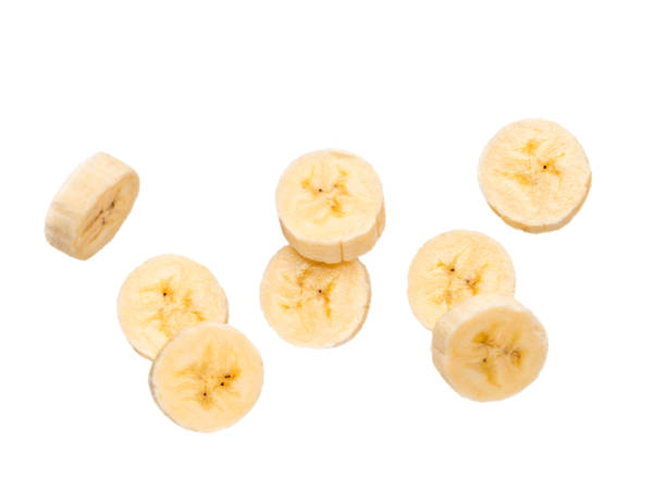 group of pairs of two slices of banana, isolated Many banana slices falling, isolated on white background with clipping path. Studio shoot. slice stock pictures, royalty-free photos & images