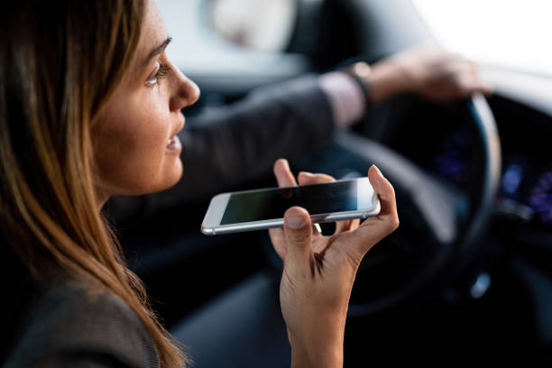 close-up da mulher que fala no telefone móvel ao conduzir um carro. - driving mobile phone car talking - fotografias e filmes do acervo