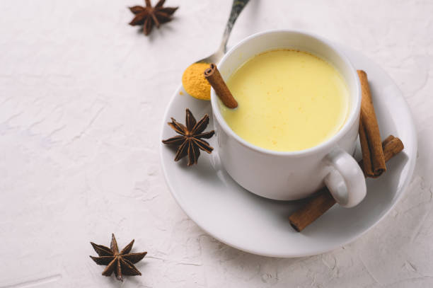 istock Golden turmeric milk with cinnamon in a white Cup on a white table 1185430092