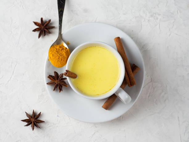 istock Golden turmeric milk with cinnamon in a white Cup on a white table 1185430103