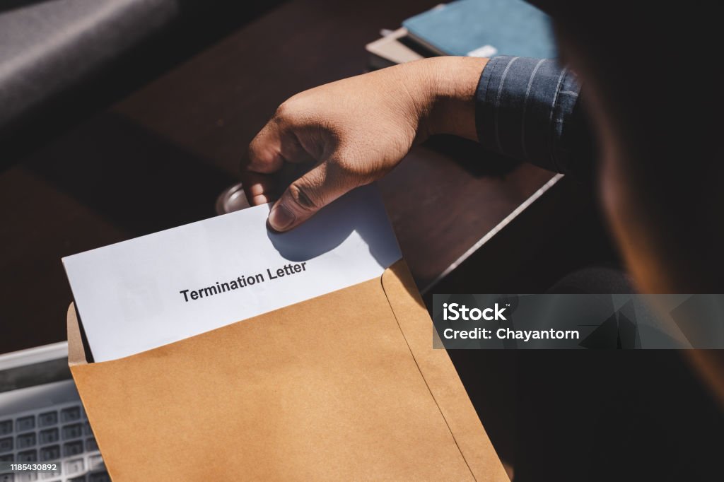 Termination of Employment and layoff concept Termination of Employment and layoff concept, Stressed businessman feeling down after received Termination of Employment Form in paper brown envelope. Finishing Stock Photo