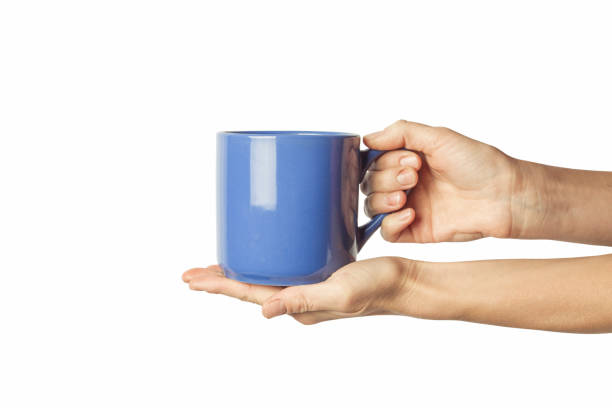 istock Female hand holding a blue cup with hot coffee on a white background. Side view 1185435606