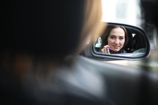 istock Girl doing makeup looking in the rear view mirror 1185435872