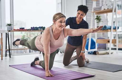 Full length shot of a mature woman doing balance and movement exercises with her physiotherapist at a rehabilitation centre