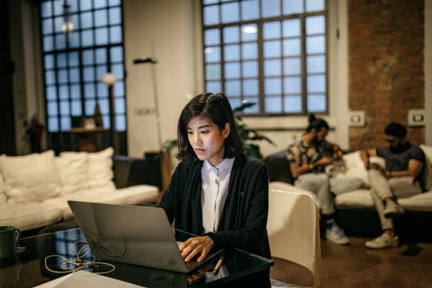 istock Working at home while her roommates sitting in living room 1185440255