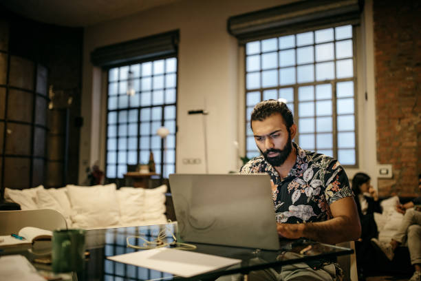 Working at home while his roommates sitting in living room