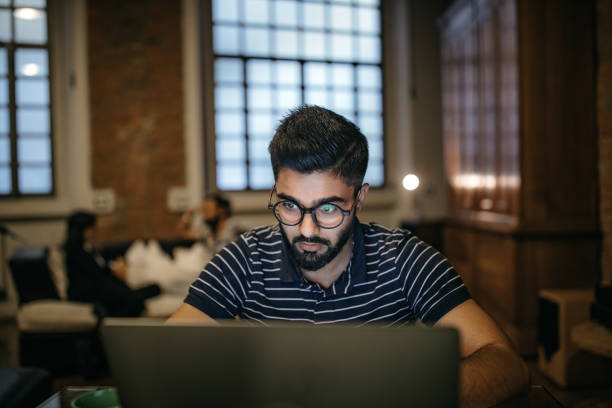 istock Working at home while his roommates sitting in living room 1185440460