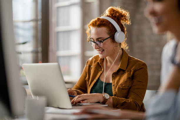 istock Happy freelance worker working on laptop while wearing headphones in the office. 1185443735