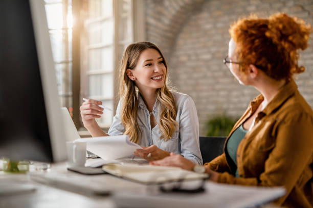 istock Young happy businesswomen communicating while working in the office. 1185443809