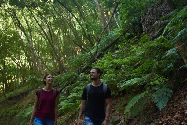istock Couple smiling as they walk in the forest 1185444437