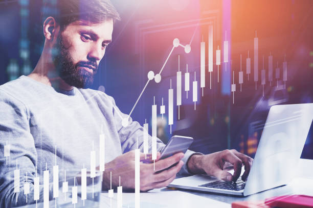 istock Man with phone and laptop, graphs 1185445808