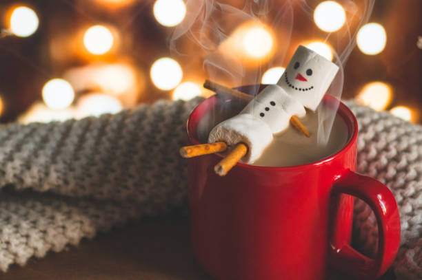 Red mug with hot chocolate with melted marshmallow snowman