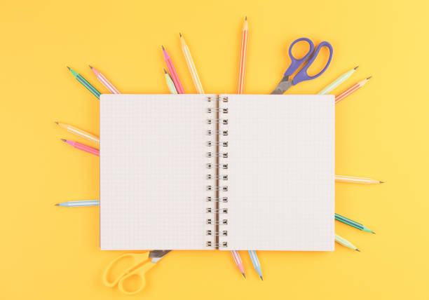 istock notebook on a yellow isolated background, office supplies 1185446348