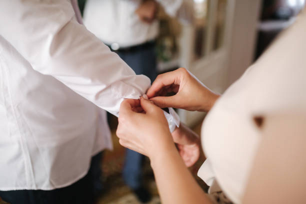 istock Somebody help groom button his shirt. Groom's morning 1185447723