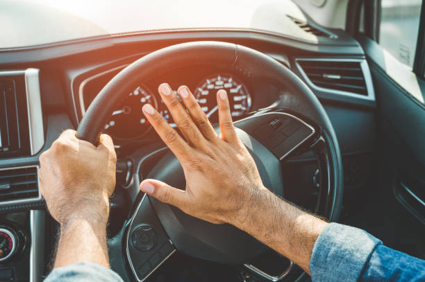 ręka człowiek pchania klaksonu samochodu podczas jazdy samochodem. - impatient zdjęcia i obrazy z banku zdjęć