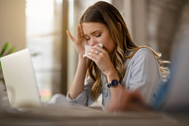 I can not believe I caught a cold! Young businesswoman with clpd and flu virus blowing nose while working in the office. desease stock pictures, royalty-free photos & images