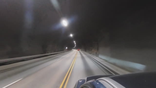 Driving through a dark car tunnel in Norway Ålesund
