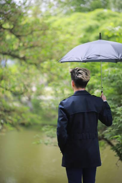 istock Spring rainy weather and a young man with an umbrella 1185454668