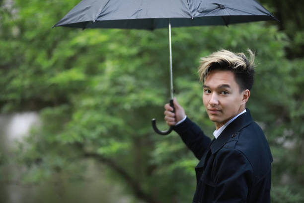 istock Spring rainy weather and a young man with an umbrella 1185454761