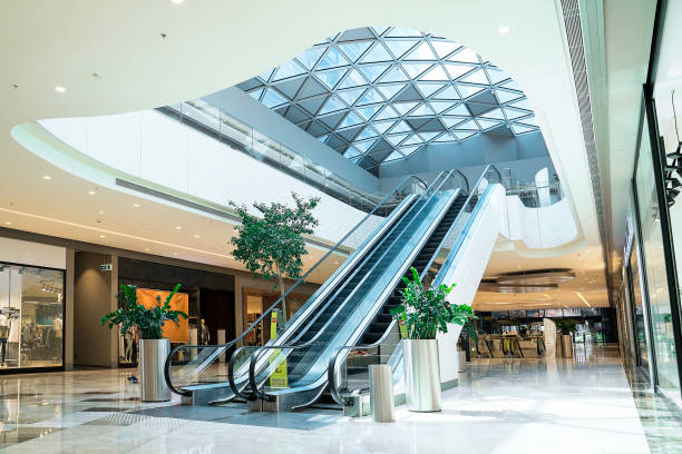 Clothing stores and escalator at shopping mall stock photo